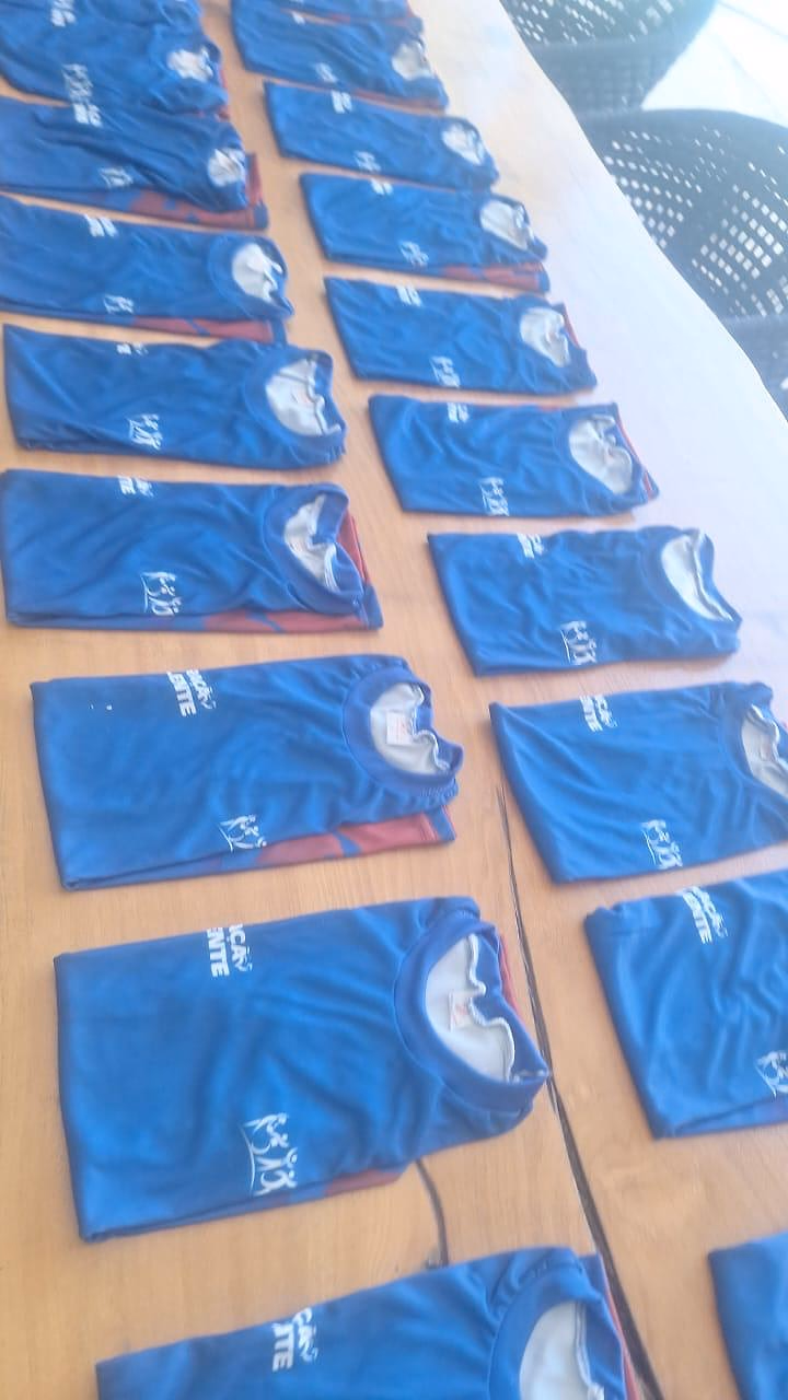 Camisas do projeto separadas uma a uma sobre a mesa, antes da entrega às crianças.