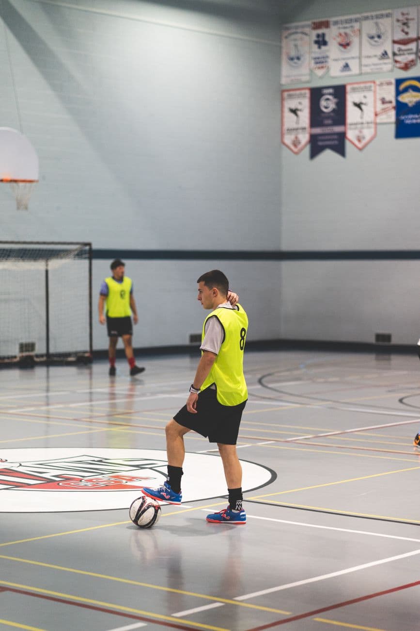 Crianças em treino de futsal em ginásio comunitário